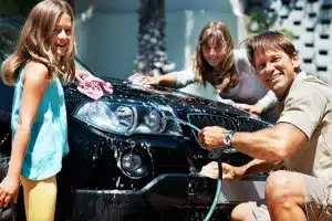 a dad spends quality time with his daughters washing the car