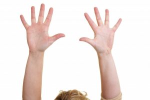 a person letting go with raised armes and open hands in the air